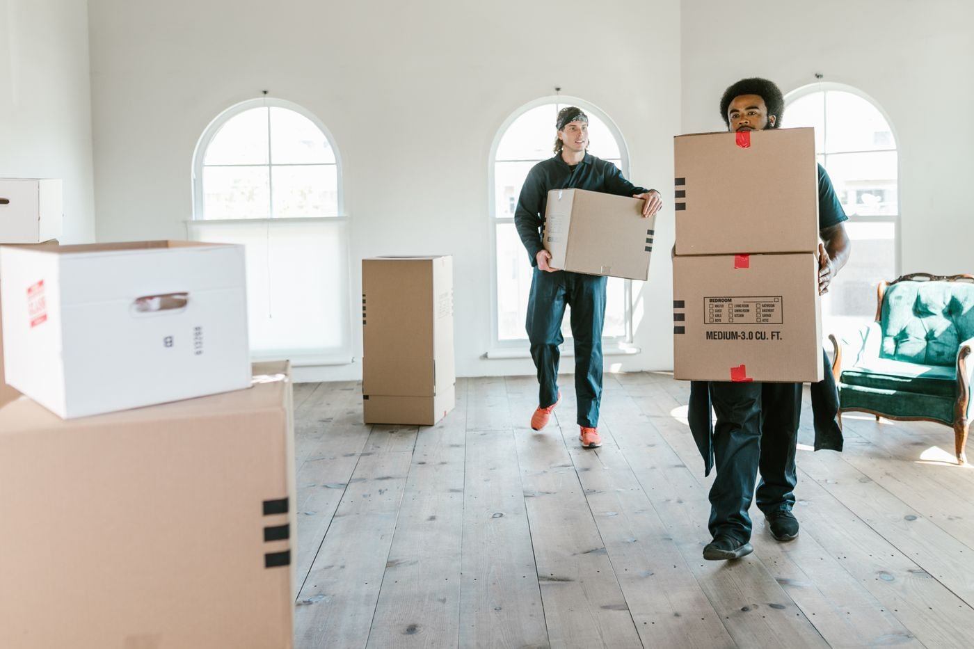 Men Carrying Boxes Inside the House — illustrative Pexels photograph