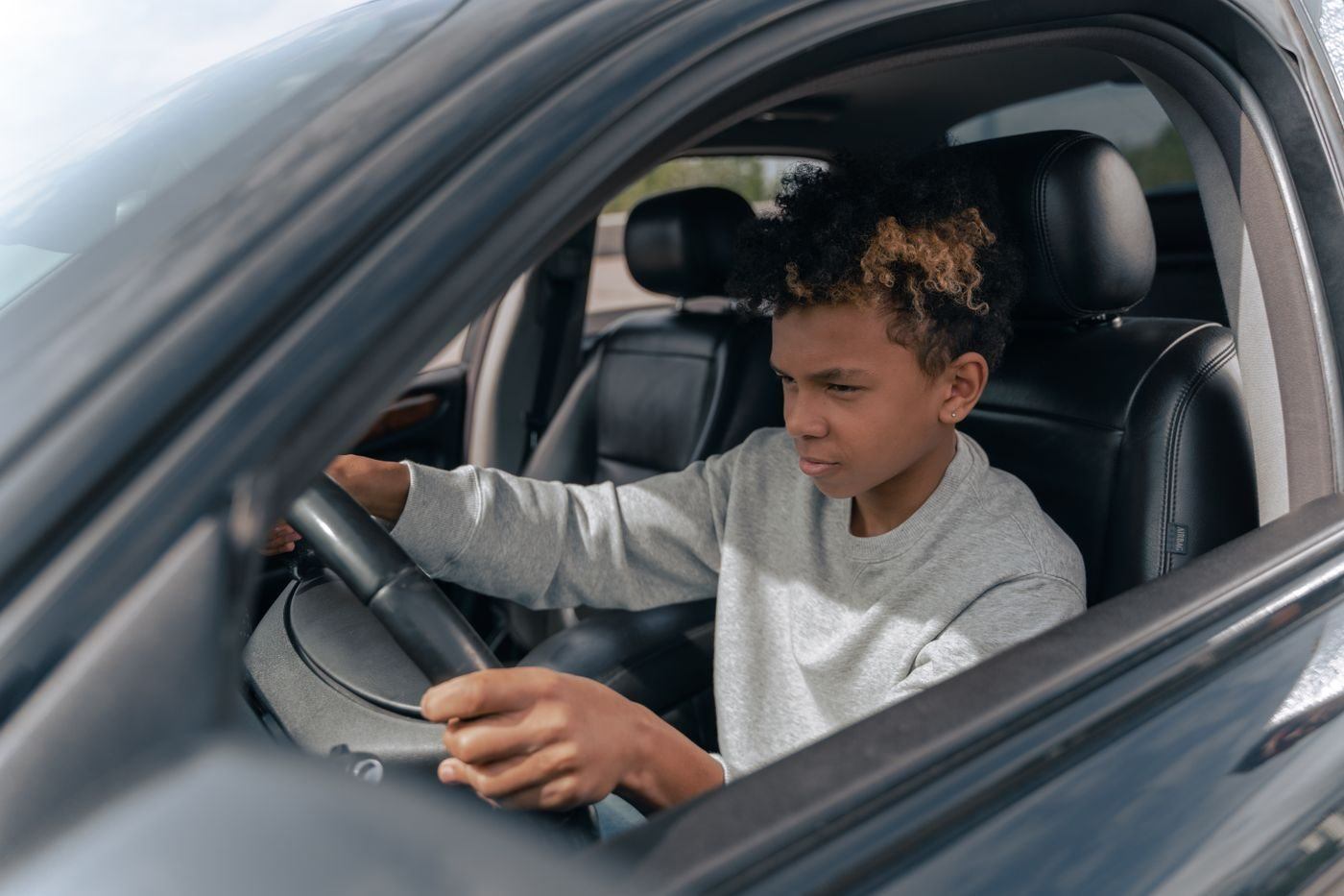 Boy in Gray Sweater Driving Car — illustrative Pexels photograph