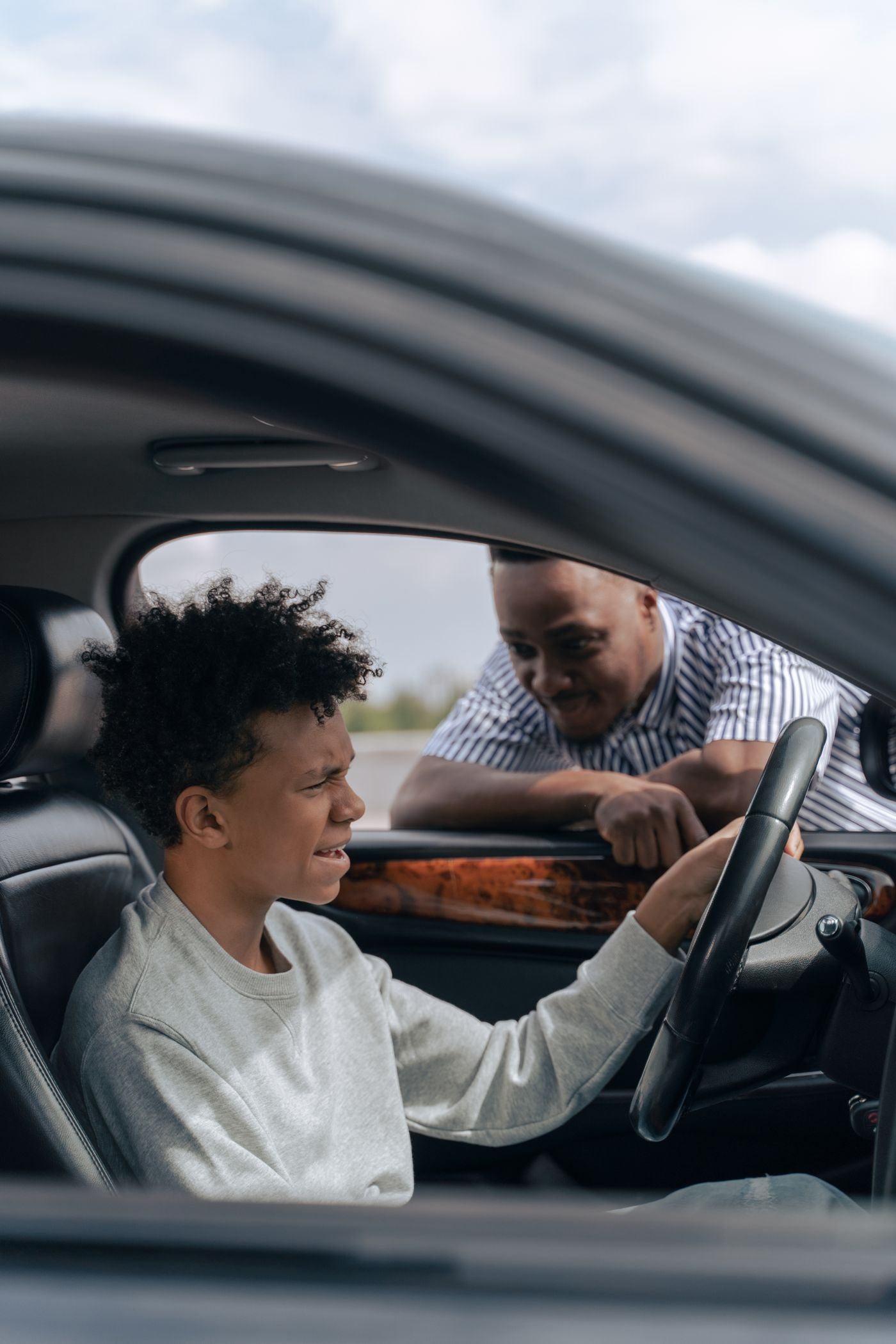 Adult Man Looking at a Teenager Seated on Driver's Side of a Car — illustrative Pexels photograph