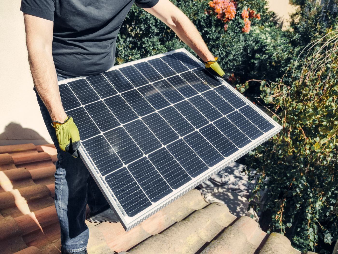 Worker installing a solar panel — illustrative Pexels photograph