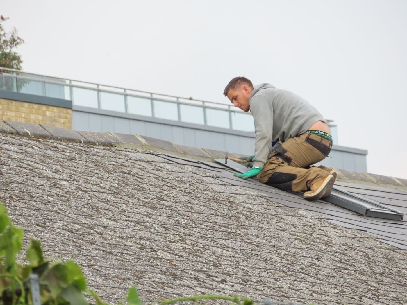 Roofer laying tiles — illustrative Pexels photograph